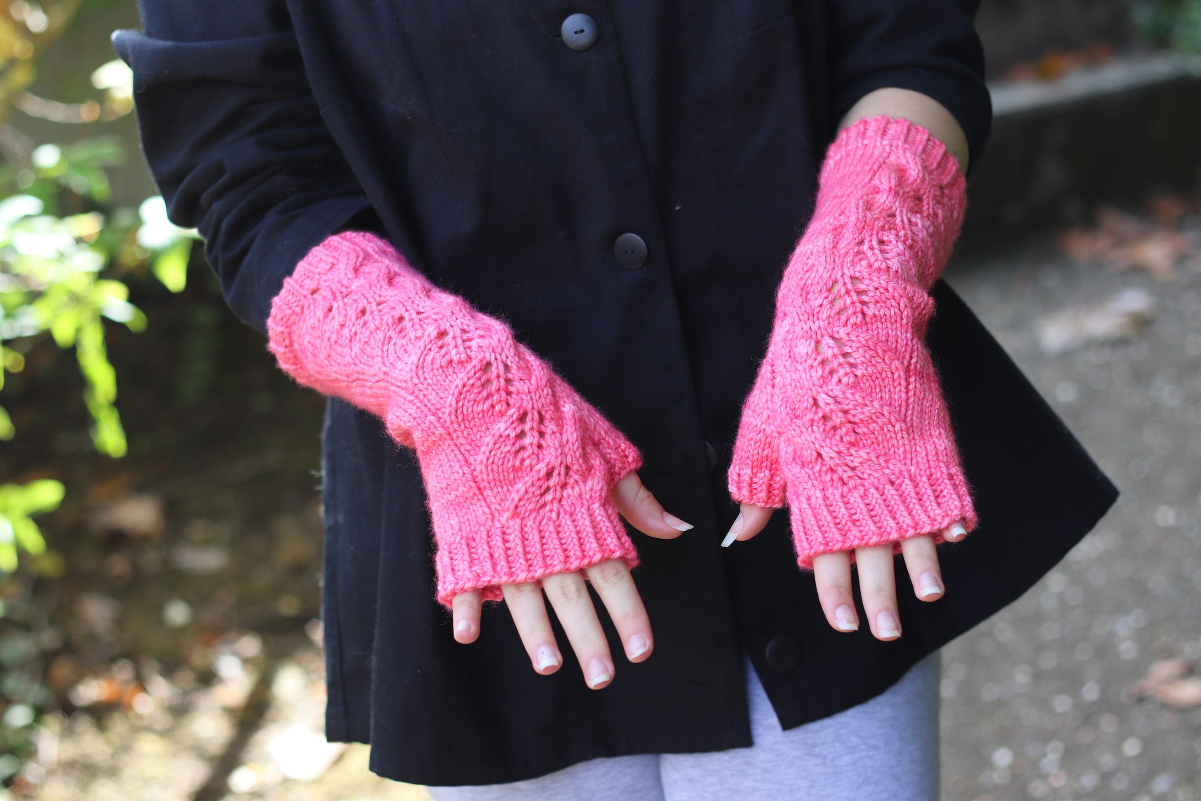 Les mitaines Jubia’S en rose Fluoro Morganite, portées sur un manteau sombre